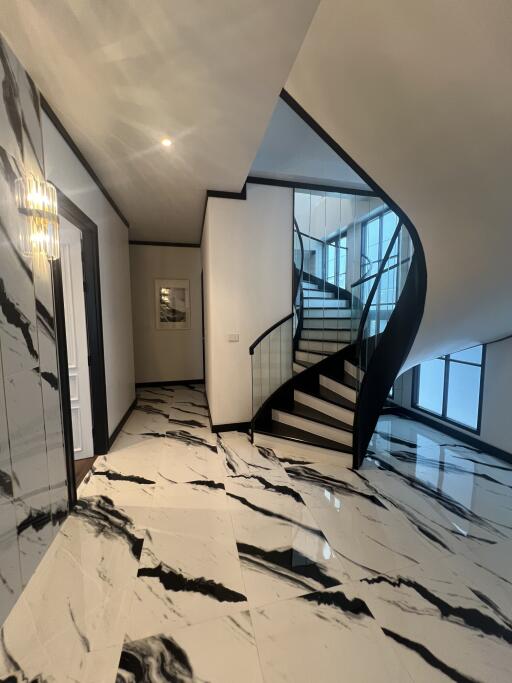 Elegant entrance hall with marble floors and a modern staircase