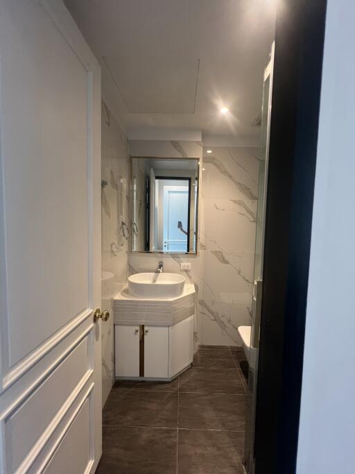 Modern bathroom with marble walls and dark tiled floor