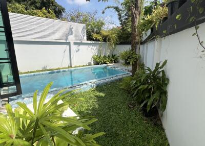 Cozy backyard with a swimming pool and lush greenery