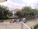 Panoramic view from a balcony overlooking the neighborhood with multiple houses and parked cars