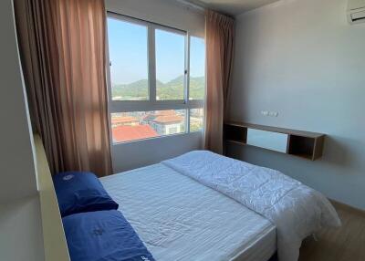 Cozy bedroom with large window and city view