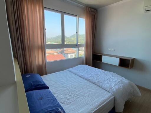 Cozy bedroom with large window and city view