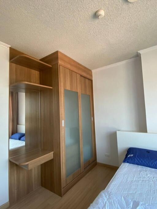 Compact bedroom with wooden wardrobe and blue bedding
