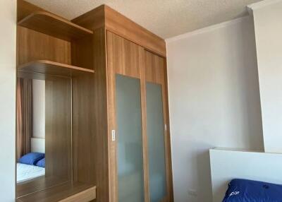 Compact bedroom with wooden wardrobe and blue bedding