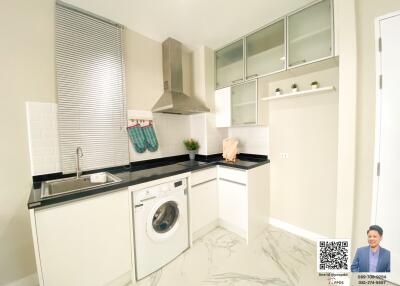 modern kitchen with washing machine, sink, stainless steel range hood, and cabinets