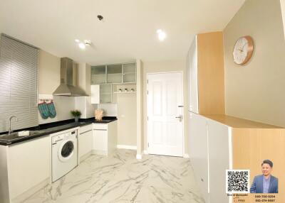 Modern kitchen with built-in appliances and marble flooring