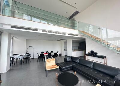 Modern open-plan living space with staircase and upper level