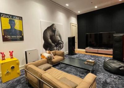 Modern living room interior with large sofa, wall-mounted TV, and artwork