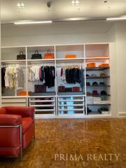 Spacious walk-in closet with built-in shelves and comfortable seating