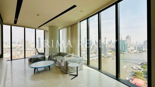 Spacious living room with large windows overlooking the city skyline and river
