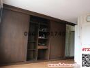 Spacious bedroom with large wooden wardrobe and open shelving units