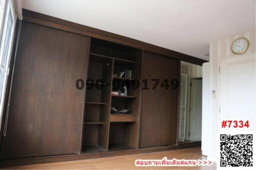 Spacious bedroom with large wooden wardrobe and open shelving units