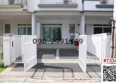 Front view of a modern house with parking space and white fence