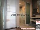 Compact apartment with sliding doors separating the bedroom, an en-suite bathroom, and a small kitchenette
