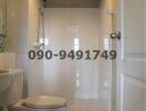 Modern white tiled bathroom with toilet and large mirror