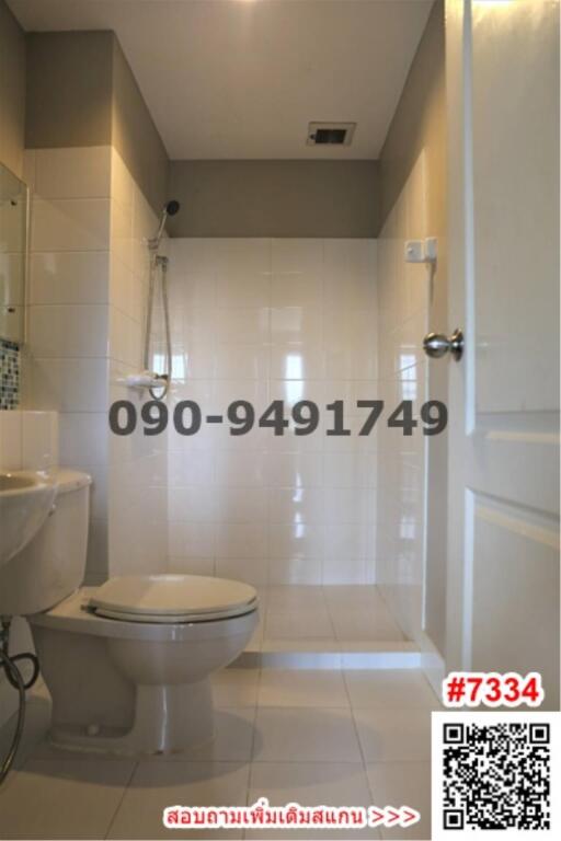 Modern white tiled bathroom with toilet and large mirror
