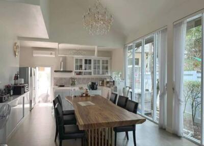 Spacious kitchen with modern appliances and large dining table under a chandelier