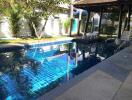 Residential swimming pool with sun loungers and landscaped garden