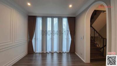 Spacious living room with natural light and staircase