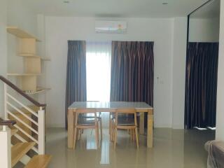 Bright living room with staircase and dining area