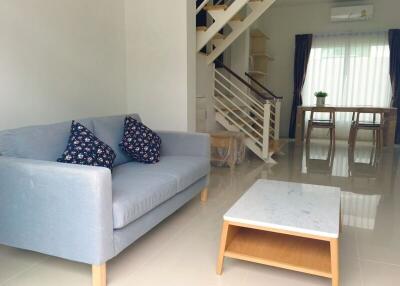 Spacious living room with modern furniture and staircase