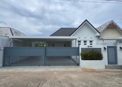 Modern single-story residential home with gray gate