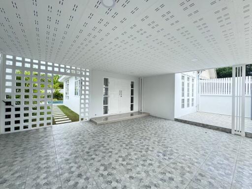 Spacious covered patio with patterned tile flooring and decorative lattice work