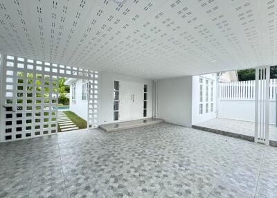 Spacious covered patio with patterned tile flooring and decorative lattice work