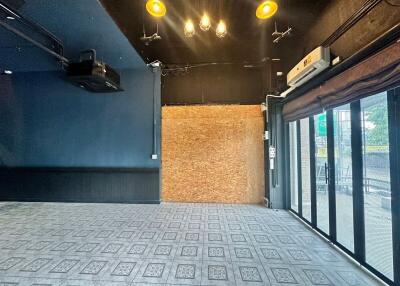 Spacious interior of a multipurpose building space with black walls and patterned floor