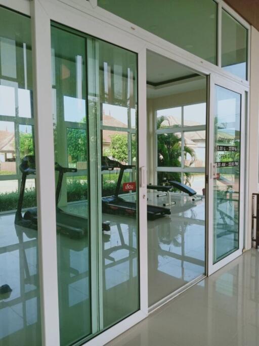 Home gym with exercise equipment behind large glass doors