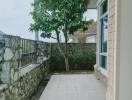 Inviting home exterior with tiled pathway and green tree