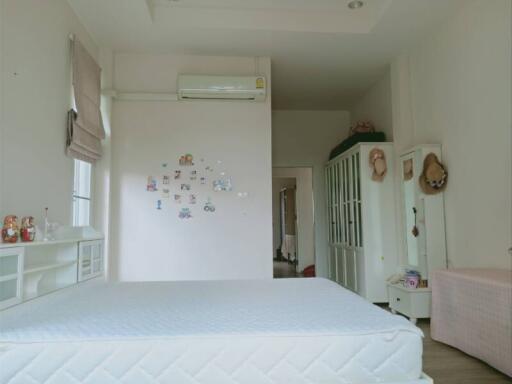 Bright and spacious bedroom with a large bed and air conditioner