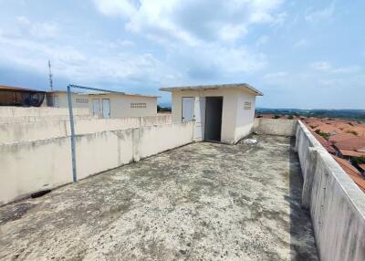 Spacious rooftop with surrounding wall and overcast sky