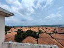 Expansive view from the balcony overlooking a residential area with red rooftops