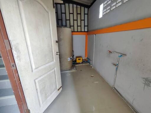 Empty garage space with white door and gray flooring