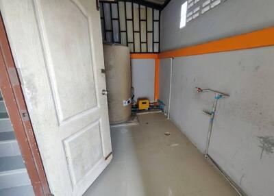 Empty garage space with white door and gray flooring