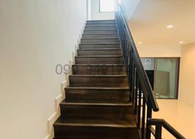 Modern staircase with wooden steps and black metal railing
