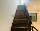 Modern staircase with wooden steps and black metal railing