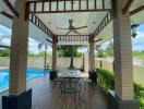 Covered patio area with swimming pool view, ceiling fan, and outdoor dining set