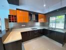 Modern kitchen with orange cabinets and black countertops