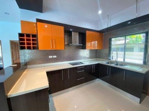 Modern kitchen with orange cabinets and black countertops