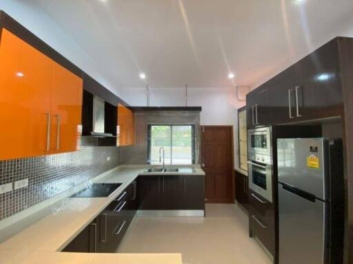 Modern kitchen with orange cabinets and stainless steel appliances