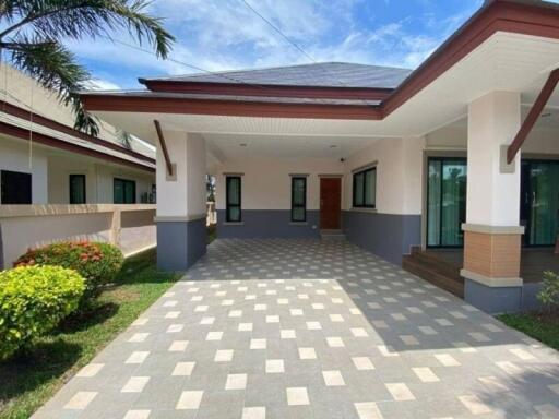 Spacious front yard with patterned driveway leading to a modern single-story house