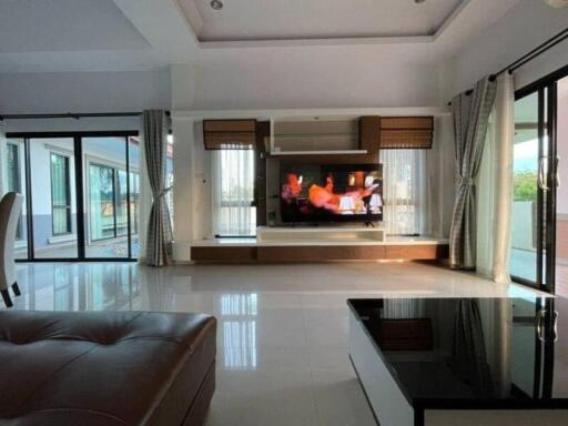 Spacious living room with large windows and modern entertainment system