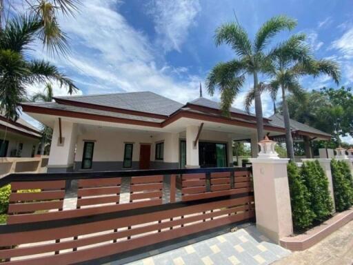 Spacious detached house with palm trees and a clear blue sky