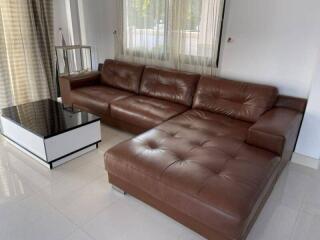 Spacious living room with a large brown leather sofa and modern decor