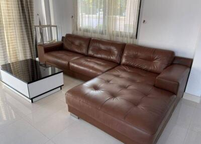 Spacious living room with a large brown leather sofa and modern decor