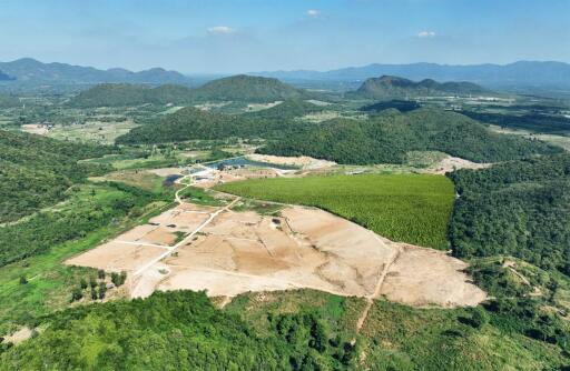 Aerial view of a large undeveloped land with mountainous backdrop