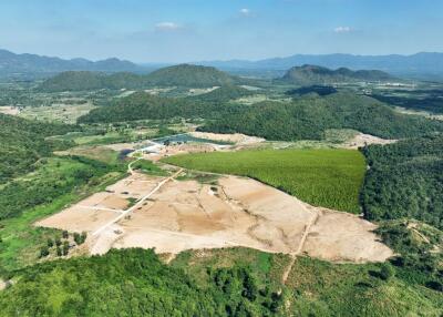 Aerial view of a large undeveloped land with mountainous backdrop