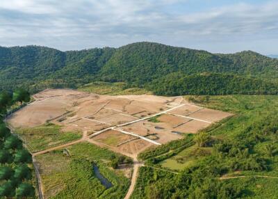 Aerial view of a rural land development surrounded by forested hills